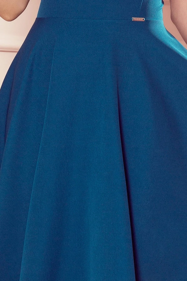 The image shows a teal flared dress with a fitted waist and a smooth, flowing skirt. The fabric appears soft and elegant, perfect for both casual and formal occasions.