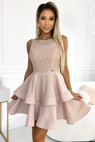 A sleeveless, blush pink dress features a fitted lace bodice and a double-layered flared skirt, creating an elegant and feminine silhouette. The intricate lace detailing adds a touch of sophistication, perfect for special occasions.}