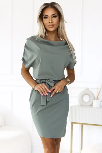 A stylish, asymmetrical dress in a muted green color features a loose-fitting top with short sleeves and a cinched waist tied with a matching belt. The elegant design is perfect for both casual and formal occasions, offering a sophisticated yet comfortable look.}