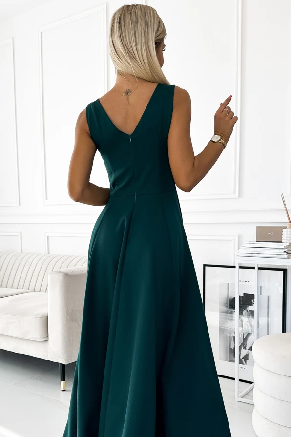 A long, elegant green dress with a V-back design flows gracefully, perfect for formal occasions. The dress features a fitted bodice and a flared skirt, creating a sophisticated silhouette.