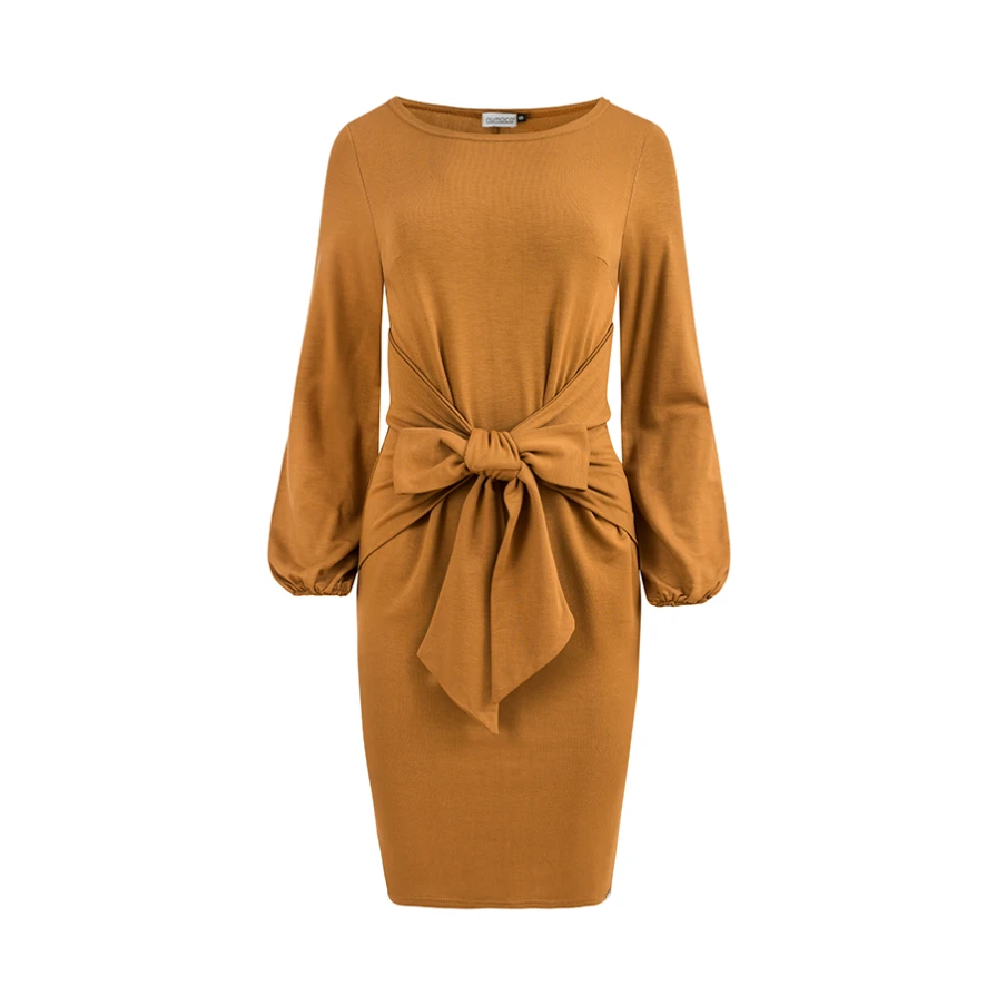 A stylish, knee-length dress in a warm caramel color features long sleeves and a unique front tie detail that accentuates the waist. The soft fabric and relaxed fit make it a comfortable yet elegant choice for various occasions.