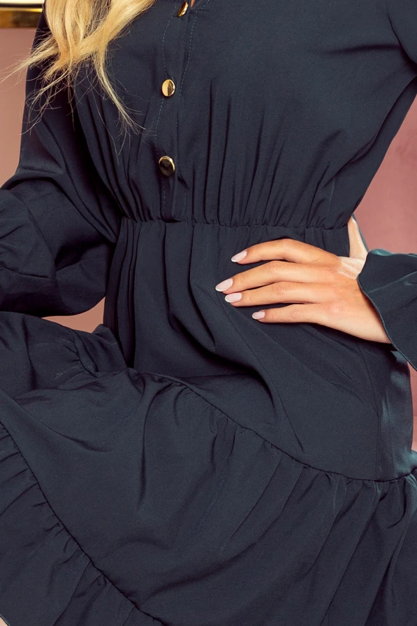 The image features a stylish dark dress with elegant ruffles and a cinched waist, accentuated by gold buttons down the front. The fabric appears soft and flowing, creating a sophisticated and feminine silhouette.
