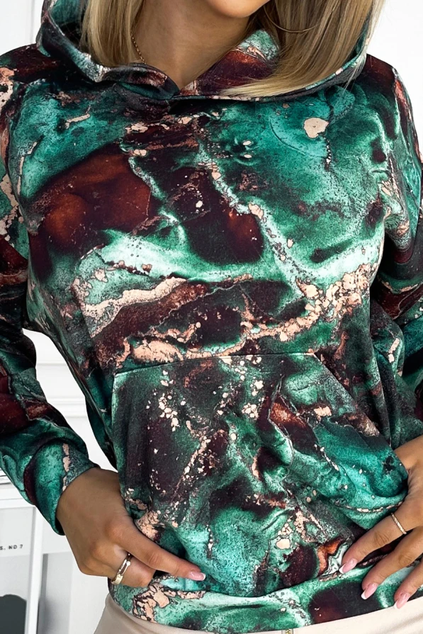 A stylish hoodie featuring a vibrant marbled pattern in shades of green and brown, complete with a cozy front pocket. The fabric has a smooth texture, adding a touch of elegance to casual wear.