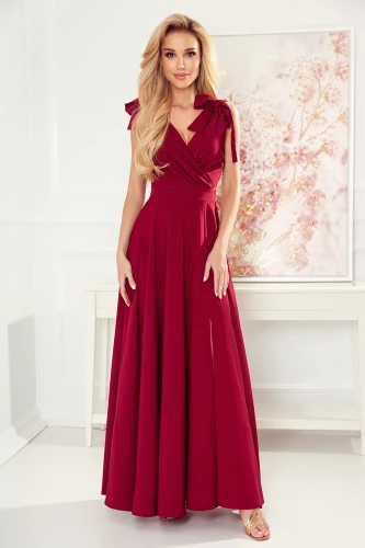 A long, elegant burgundy dress with a fitted bodice and flowing skirt, featuring delicate shoulder ties for added charm. The dress exudes sophistication, perfect for formal occasions or evening events.}