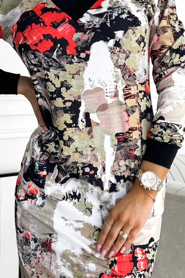A vibrant dress featuring an abstract pattern with splashes of red, black, and beige, creating a bold and artistic look. The design includes a V-neckline and long sleeves, perfect for making a stylish statement.