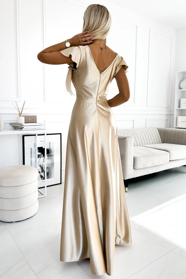 A long satin dress in a shimmering champagne color features a deep V-back and flutter sleeves, creating an elegant and sophisticated look. The flowing skirt adds a touch of grace, perfect for formal occasions.