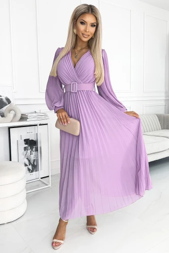 A pleated lavender dress with long sleeves and a matching belt, creating an elegant and flowing silhouette. The dress is paired with a nude clutch and strappy heels, perfect for a sophisticated occasion.}