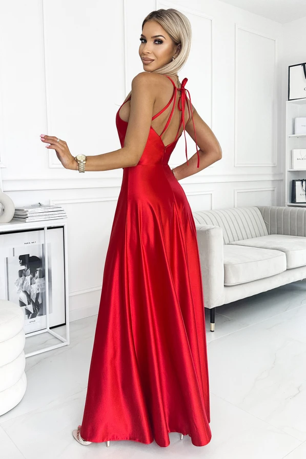 A long, satin evening gown in a vibrant red color features a fitted bodice with delicate spaghetti straps that tie at the back. The dress flows elegantly to the floor, creating a graceful and sophisticated silhouette.