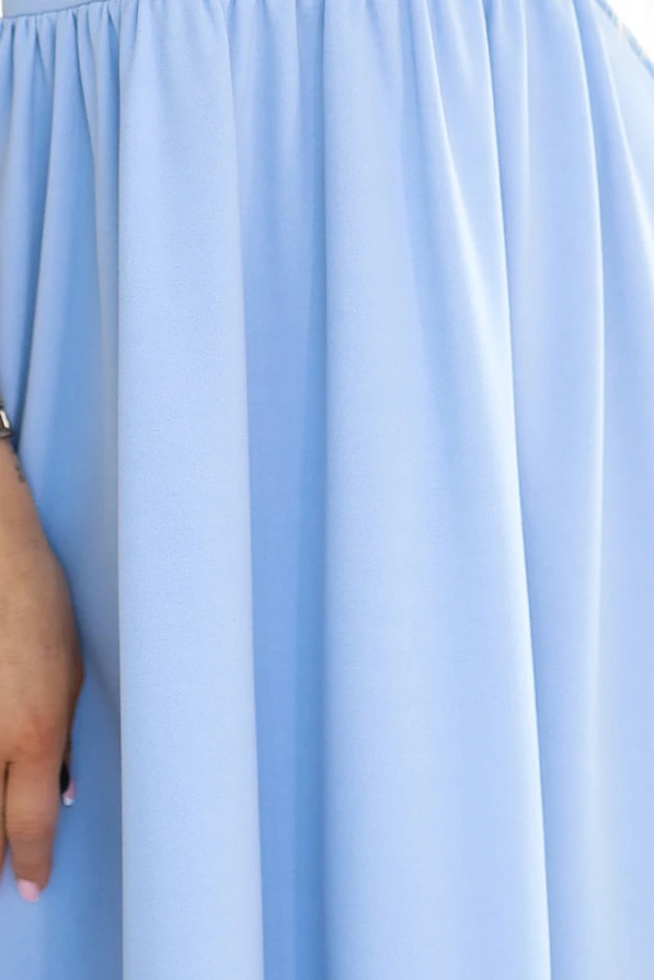 The image shows a light blue dress with a flowing, gathered skirt that creates a soft and elegant silhouette. The fabric appears smooth and lightweight, perfect for a breezy, stylish look.