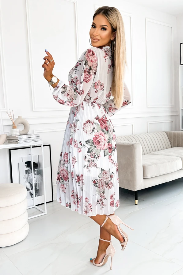 A pleated dress with a delicate floral pattern in shades of pink and green, featuring long sleeves and a fitted waist. The lightweight fabric and elegant design make it perfect for both casual and formal occasions.