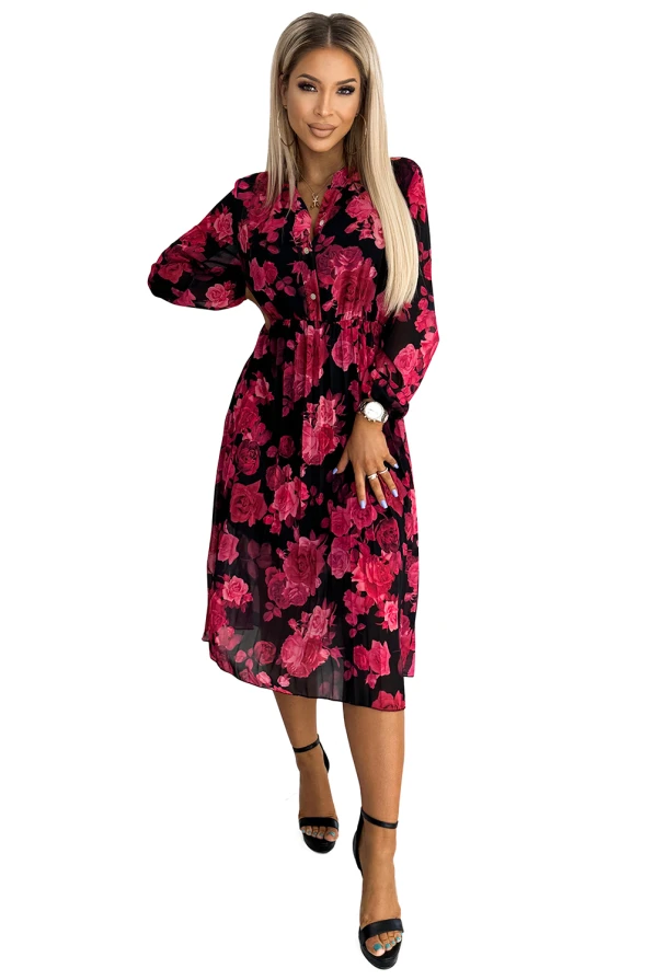 A pleated dress featuring a vibrant floral pattern in shades of pink on a black background. The dress has long sleeves and a flowing, knee-length silhouette, perfect for both casual and formal occasions.
