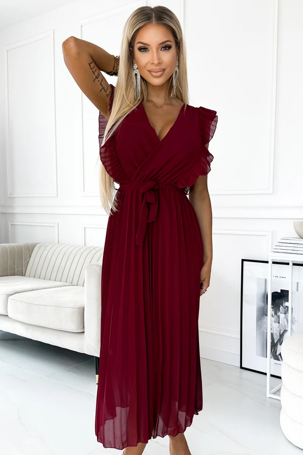 A burgundy pleated dress with flutter sleeves and a wrap-style bodice, cinched at the waist with a matching belt. The elegant design is complemented by a flowing skirt, perfect for formal occasions.