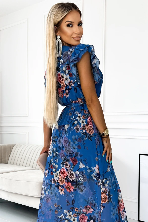 A long, elegant dress in a vibrant blue color features a delicate floral pattern, perfect for special occasions. The dress is complemented by ruffled sleeves and a cinched waist, adding a touch of sophistication and femininity.