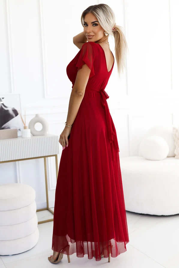 A long, elegant red dress with a flowing skirt and short sleeves, featuring a tied waist for a flattering silhouette. The dress is perfect for formal occasions, offering a sophisticated and timeless look.