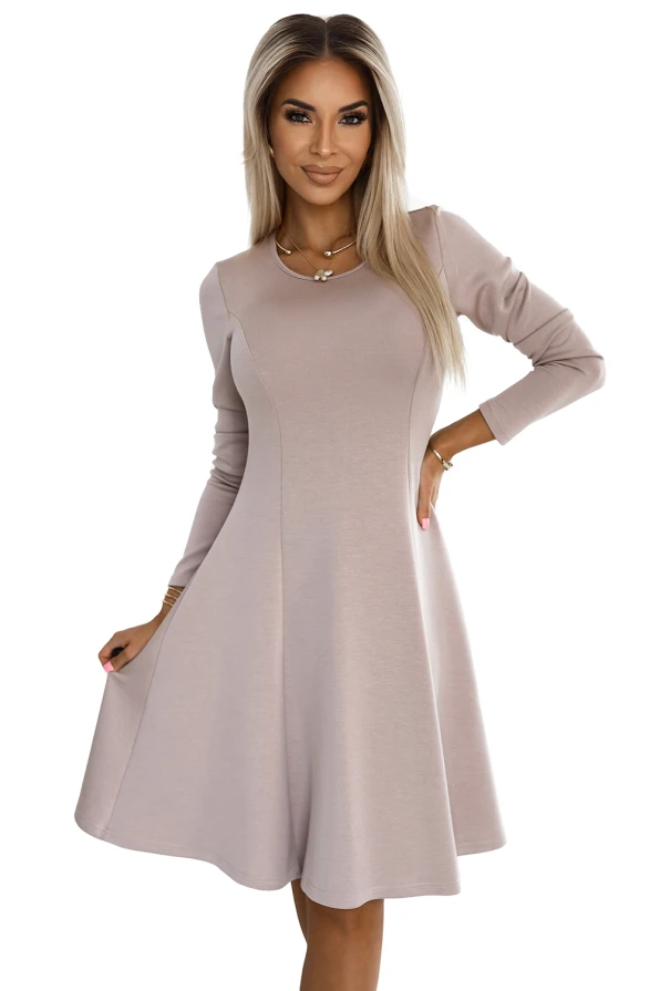 A comfortable trapeze dress in a soft beige color, featuring long sleeves and a flattering A-line silhouette. The dress is made from a smooth fabric that drapes elegantly, perfect for both casual and formal occasions.