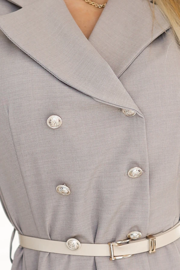 The image features an elegant, light gray shirt dress with a double-breasted design and decorative buttons. It includes a matching belt that accentuates the waist, adding a sophisticated touch to the overall look.